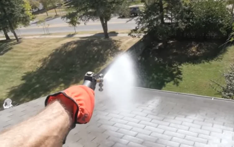 a hand treating the roof with spraying chemical on it. Roof treatment and maintenance Naples service
